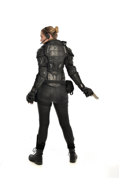 po celé délce portrét ženské voják nosí černé taktické brnění drží zbraň, izolované na bílém studio pozadí. - Fotografie, Obrázek