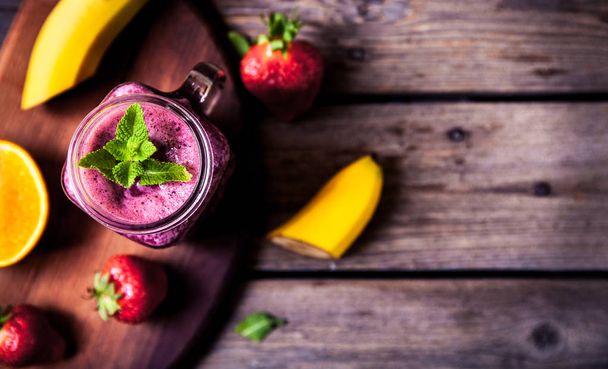 Blueberry smoothies on a wooden background with fruits. Vitamins - Photo, image