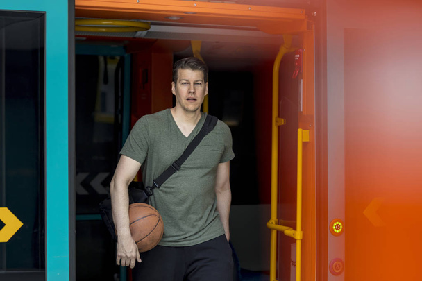 Sportif adam ile bir basketbol yürüyüş bir metro treninin dışında - Fotoğraf, Görsel