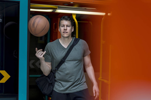 Sportowy człowiek z koszykówki zaraz po wyjściu z pociągu metra - Zdjęcie, obraz