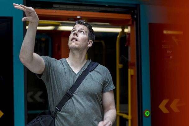 Спортивний чоловік з баскетболом вийшов з потягу метро
 - Фото, зображення