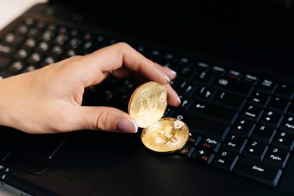 woman holds a crypto currency on a laptop background - Zdjęcie, obraz