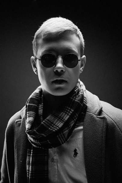 Handsome young man in stylish sunglasses and scarf posing  - Foto, Imagem