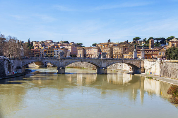 ROME, ITALY, on March 7, 2017. A view of the Tiber River and of Victor Emmanuil II Bridge connecting river banks Tiber - Zdjęcie, obraz
