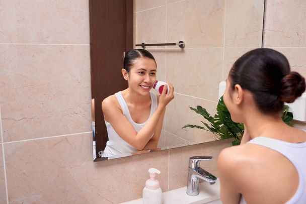 Portrait de jeune femme avec une peau parfaite démaquillant avec brosse nettoyante
 - Photo, image