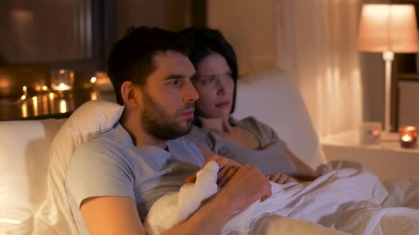 scared couple watching horror on tv at night - Video, Çekim