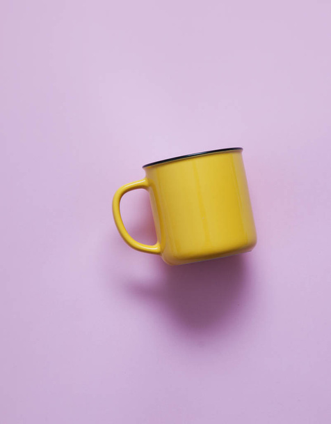Empty yellow cup on pastel background. - Фото, изображение