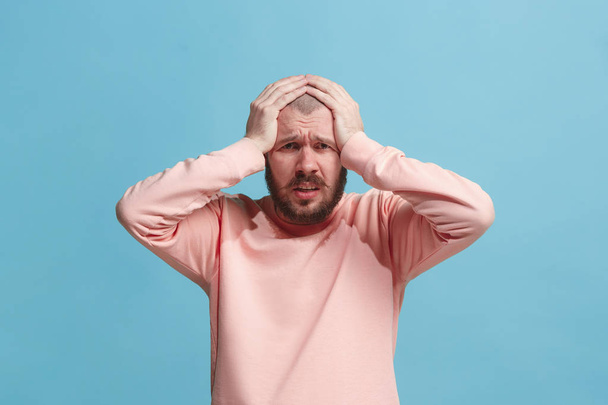 Man having headache. Isolated over blue background. - Foto, afbeelding