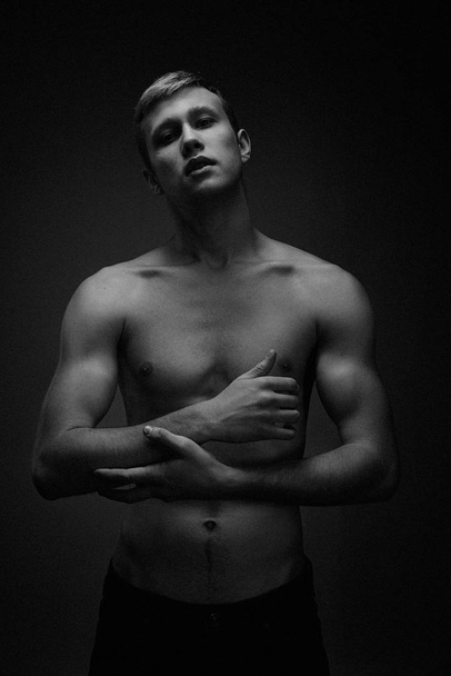 Handsome young shirtless man posing against studio background  - Valokuva, kuva