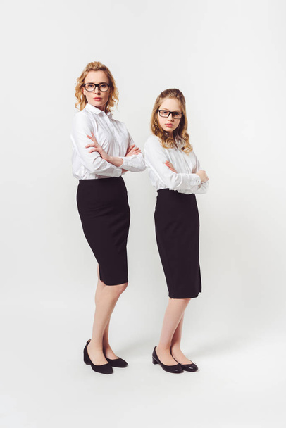 deux femmes d'affaires de différentes générations avec les bras croisés sur blanc
 - Photo, image