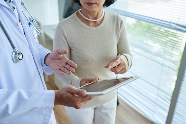 Cropped image of doctor explaining prescription to mature female patient - Photo, Image