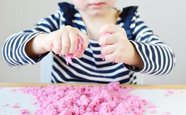 Little Caucasian Girl Playing with Pink Kinetic Sand at Home, Early Education, Preparing for School, Development - Photo, Image