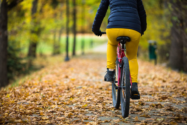 Urban biking - woman riding bike in city park - Zdjęcie, obraz