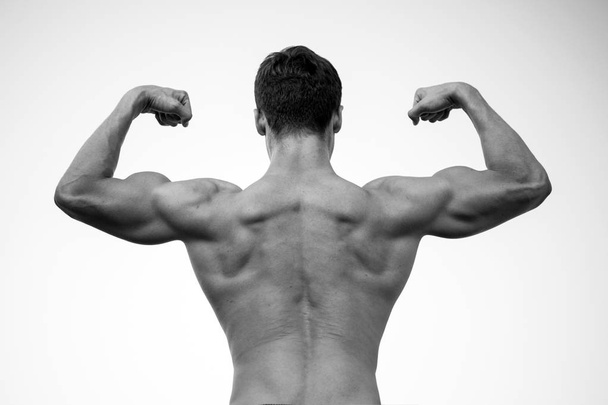 Man or sportsman flexing arms with fists, back view - Photo, Image