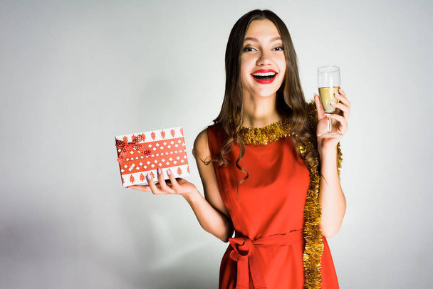 woman on a gray background celebrates the coming of the new year with champagne in her hands - Photo, image