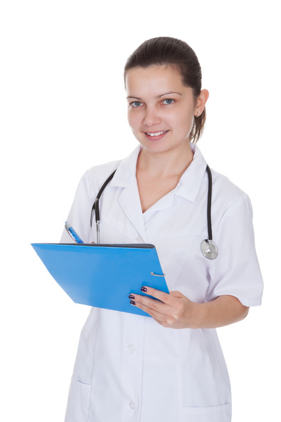 Cheerful young nurse writing a report - Photo, Image