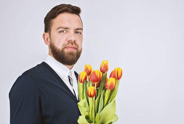 Charming man with bouquet of tulips - Valokuva, kuva