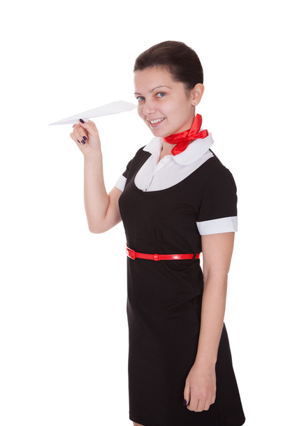 Beautiful flight attendant with paper airplane - Фото, изображение
