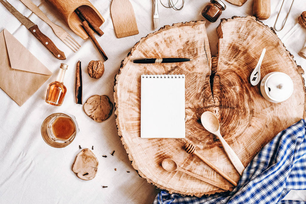 Bovenaanzicht van sawed hout met laptop, pen en keuken accessoires - Foto, afbeelding