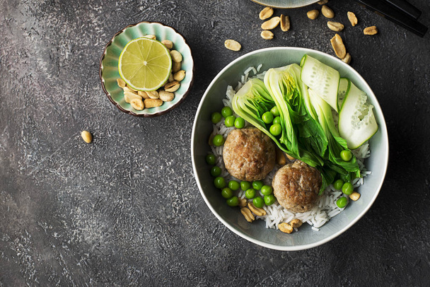Meatballs, rice, bok choy bowl on a gray background with a ceramic dish. Flat lay. Top view. - Valokuva, kuva