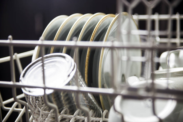 Чистые тарелки и чашки в посудомоечной машине. Домашнее оборудование. Голубая сельская посуда
 - Фото, изображение