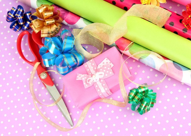 Rolls of Christmas wrapping paper with ribbons, bows on color background - Foto, Imagen