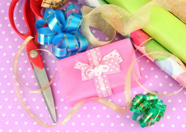 Rolls of Christmas wrapping paper with ribbons, bows on color background - Φωτογραφία, εικόνα