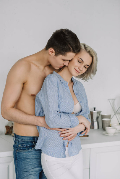 seductive young couple hugging at kitchen - Foto, afbeelding