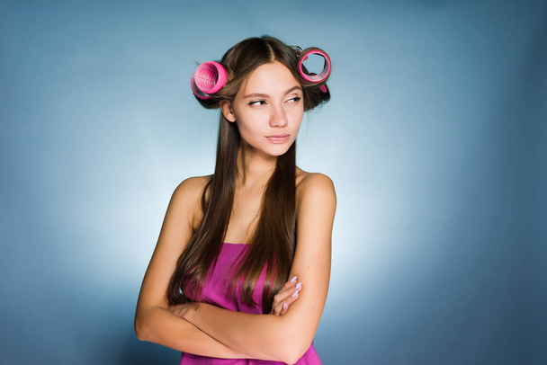 angry woman with curlers on her head on a blue background - Foto, immagini
