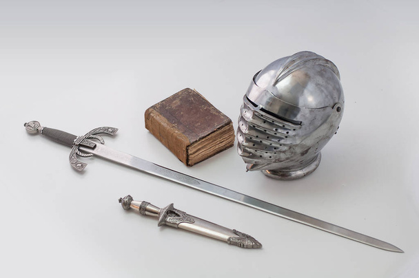 Rytířská helma s hledí, dýka, meč a kniha - Fotografie, Obrázek
