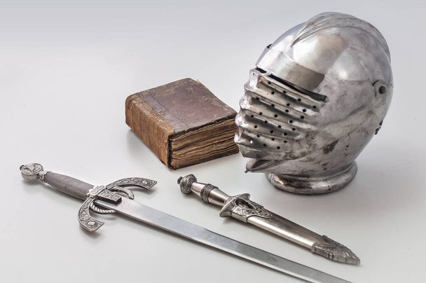 Hełm rycerza z wizjera, sztylet, miecz i książki - Zdjęcie, obraz