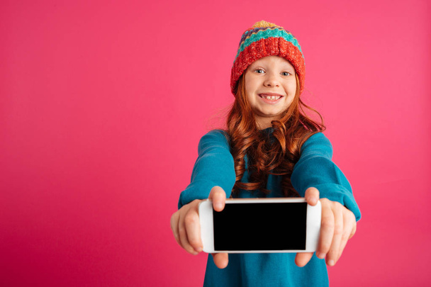 Surprised happy girl showing smartphone with blank screen and smiling isolated - Фото, зображення