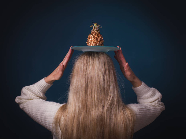 Χρυσή ανανά φρούτα στο κεφάλι της γυναίκας - Φωτογραφία, εικόνα