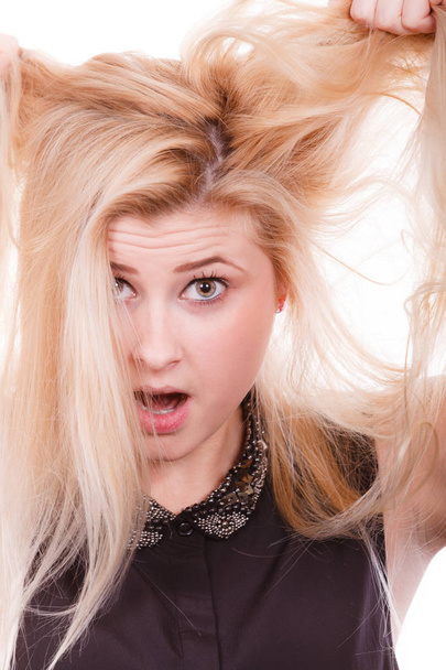 Blonde woman holding her dry hair - Fotografie, Obrázek