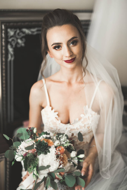Gorgeous bride in robe posing and preparing for the wedding ceremony face in a room - Φωτογραφία, εικόνα
