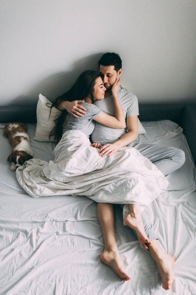 A photo session of a guy and a girl in a cozy home environment. A family member is a little dog. - Fotoğraf, Görsel