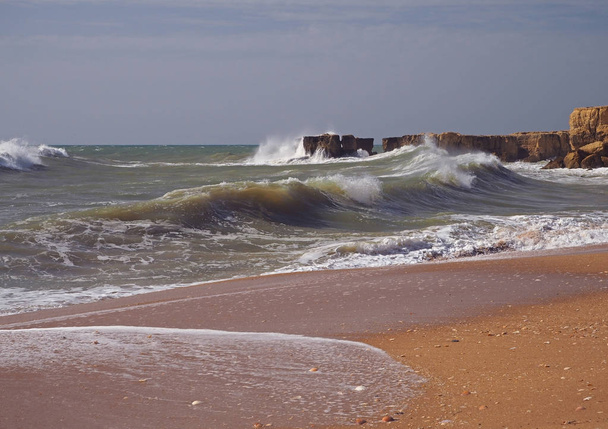 φουρτουνιασμένη θάλασσα άμμο παραλία με όμορφα ψαμμίτη - Φωτογραφία, εικόνα