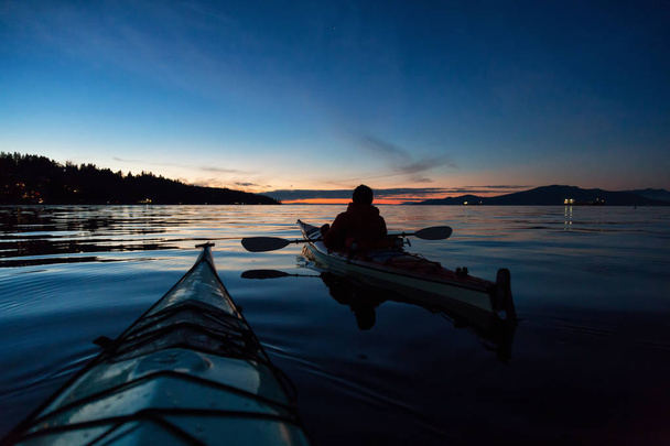 Man Kayaking on a sea kayak during a vibrant sunset. Taken near Jericho Beach, Vancouver, British Columbia, Canada. - Fotó, kép
