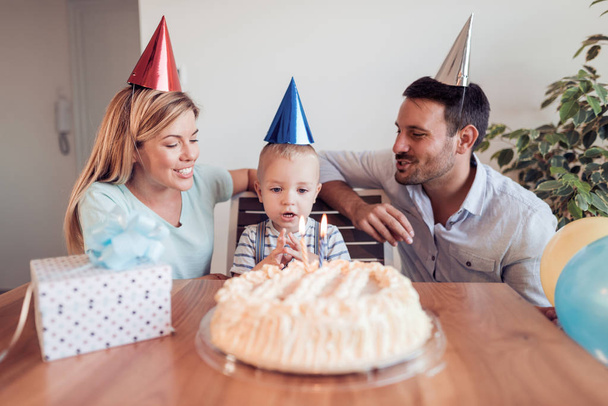 glückliche Familie feiert Geburtstag zu Hause im Wohnzimmer. - Foto, Bild