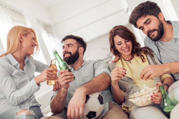 Jóvenes con cerveza viendo fútbol en casa
. - Foto, imagen