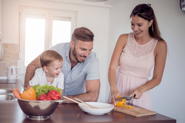 Šťastná rodina přípravy zeleniny dohromady doma v kuchyni. - Fotografie, Obrázek