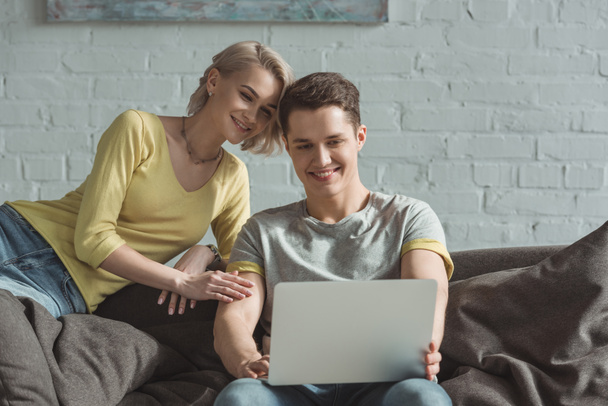 ευτυχισμένο ζευγάρι ψάχνει στο φορητό υπολογιστή στο σπίτι - Φωτογραφία, εικόνα