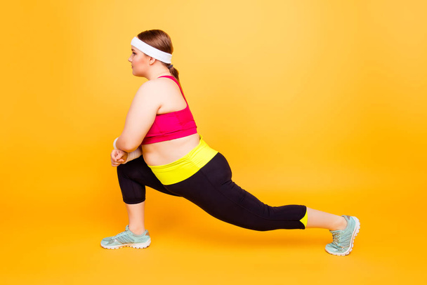 Side view image of concentrated flexible plump woman clothed in  - Photo, Image