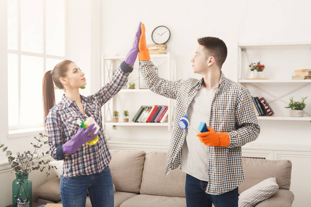 Пара, дающая друг другу пять, держащая в руках моющее оборудование
 - Фото, изображение