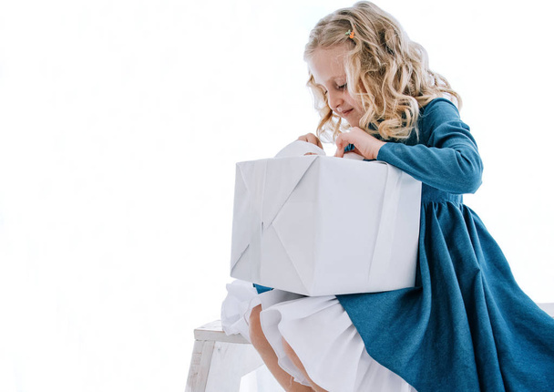 девушка открывает подарочную коробку на белом фоне
 - Фото, изображение