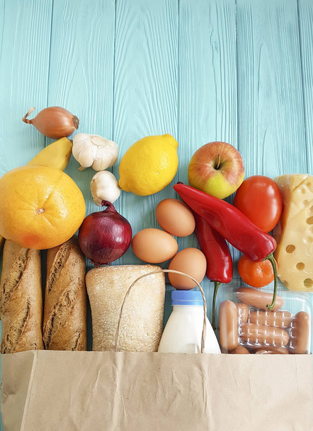 sac en papier avec différents aliments utiles, légumes et fruits sur bois bleu
 - Photo, image