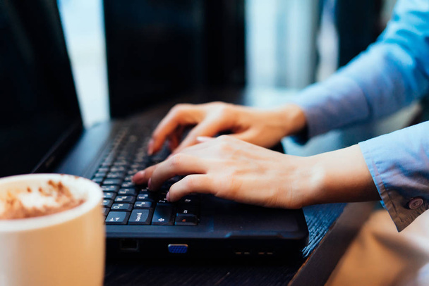 a woman types something on a laptop - Фото, изображение