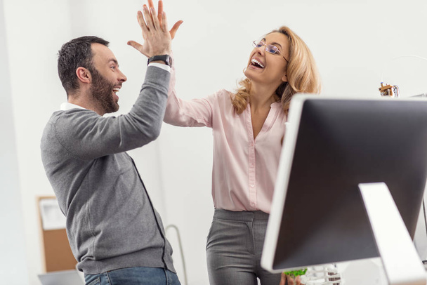 Happy colleagues giving each other a high-five - Photo, image
