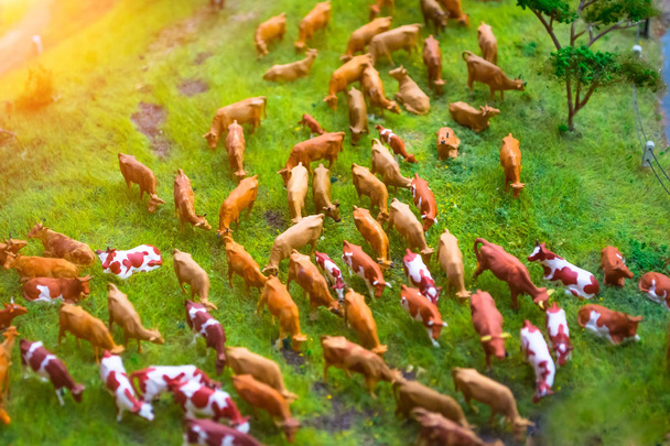 Стадо корів мініатюрні іграшки на лужному фермерському ландшафті, вид зверху
. - Фото, зображення