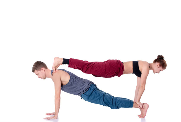 Young athletic couple practicing acroyoga. Balancing in pair - Φωτογραφία, εικόνα